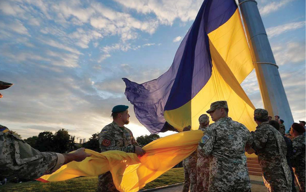 Soldiers raise the Ukrainian flag. (From Ukrainian Weekly, Oct. 22, 2021)